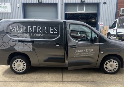 White vinyl text and printed leaf watermark for Mulberries The Florist