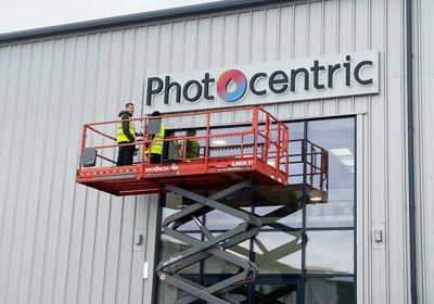 Acrylic sign backlit with aluminium tray fitted to wall cladding for Photocentric