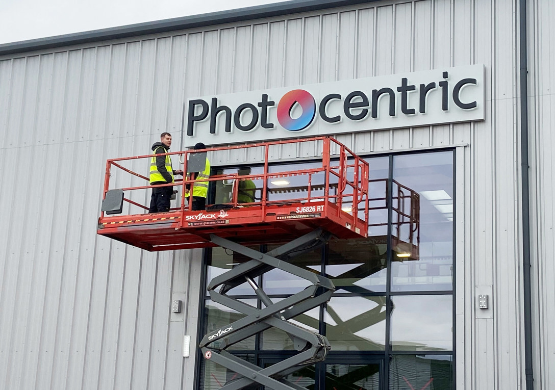 Acrylic sign backlit with aluminium tray fitted to wall cladding for Photocentric